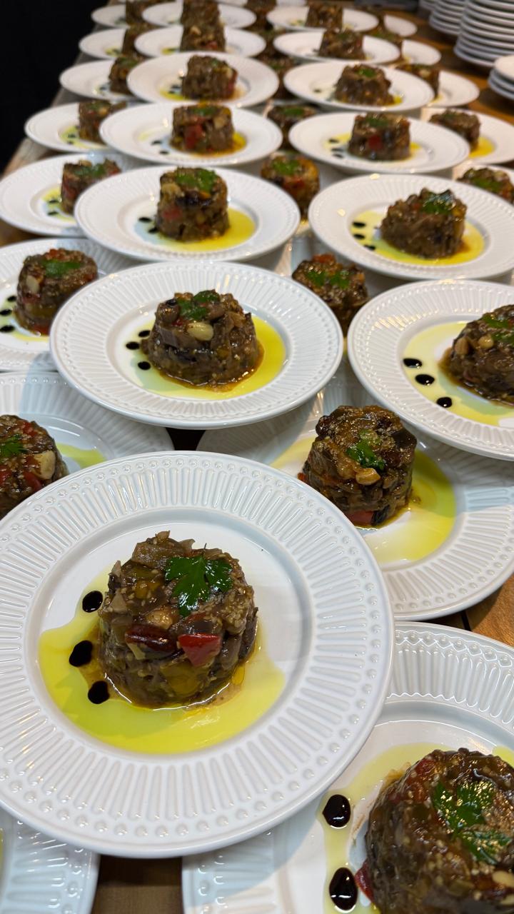 Pratos individuais do menu degustação, enfileirados e prontos para servir, com azeite e redução
