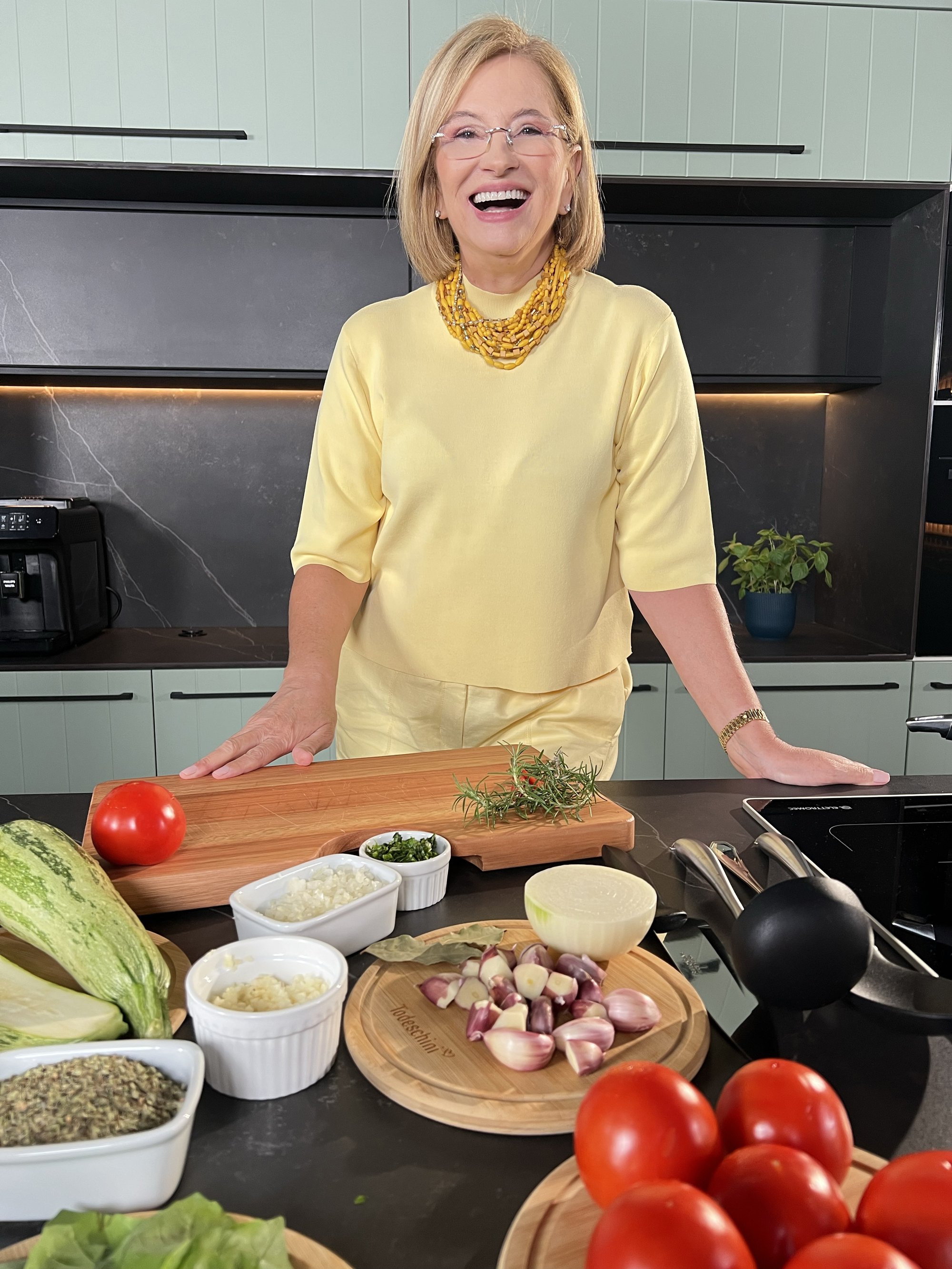 Sylvia Nogueira Cury na cozinha, com os ingredientes na bancada